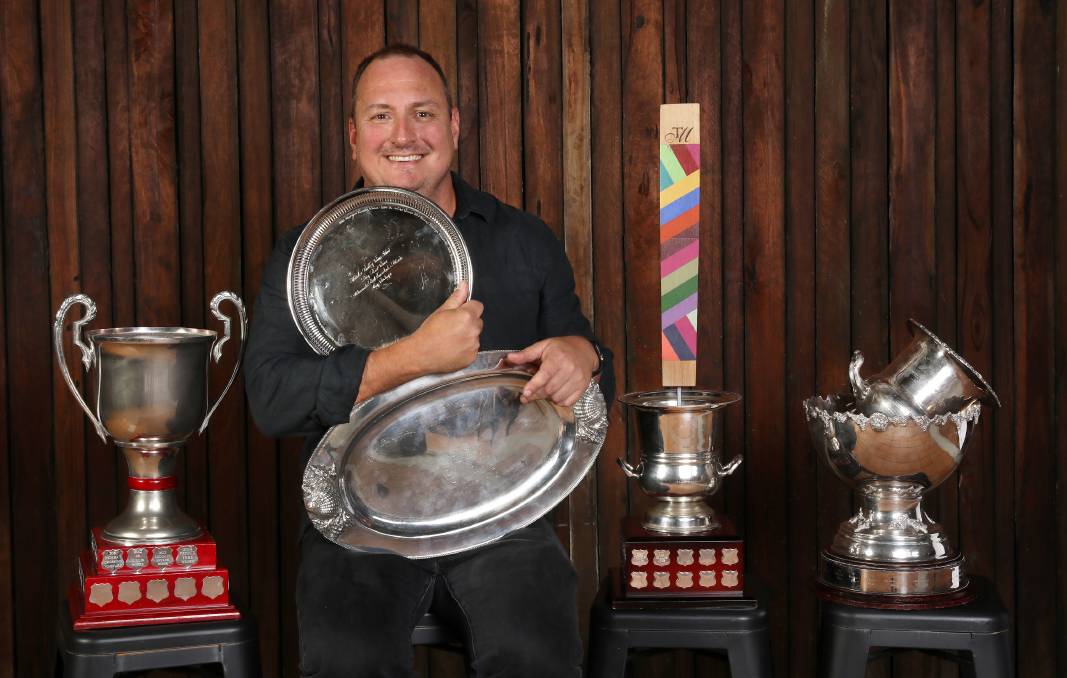 A man holding awards 